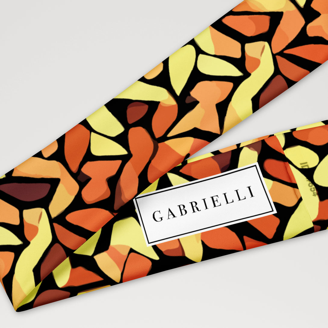 stretch headband with an abstract print in orange, yellow and brown by The Gabrielli