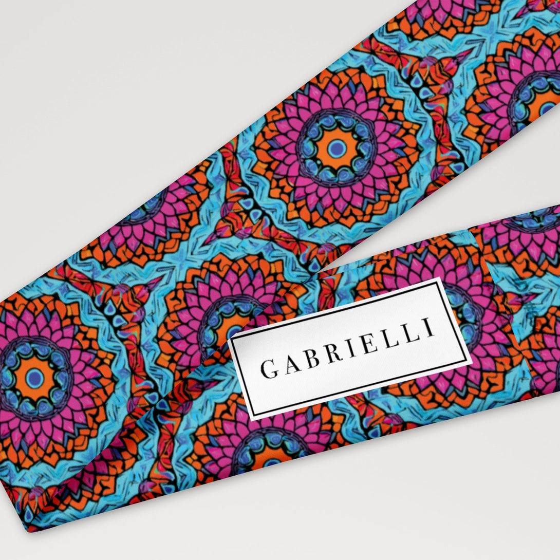 stretch headband with an abstract print in blue, pink, and orange by The Gabrielli