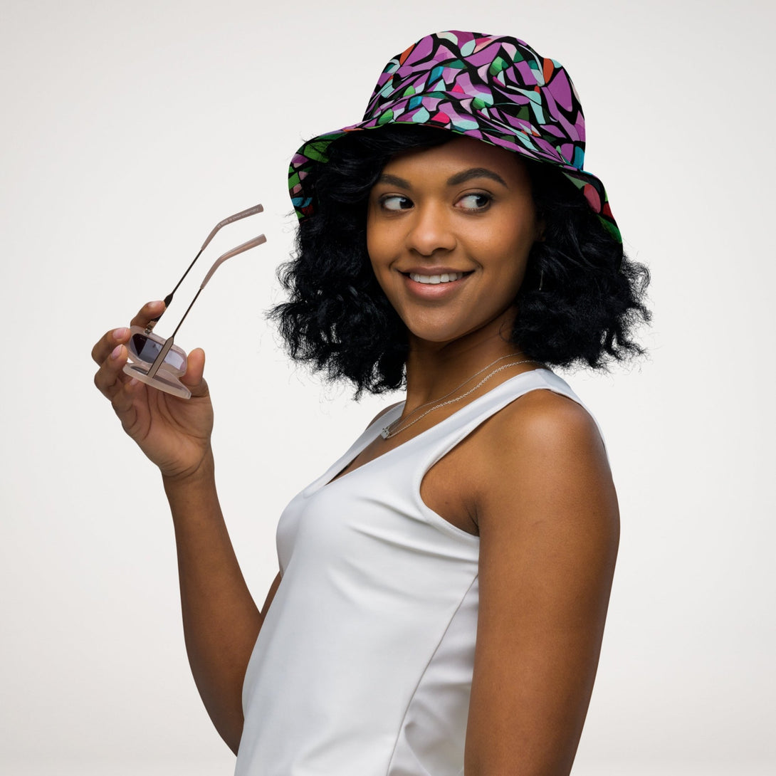 reversible bucket hat with a purple abstract print on one side and a green abstract print on the other side